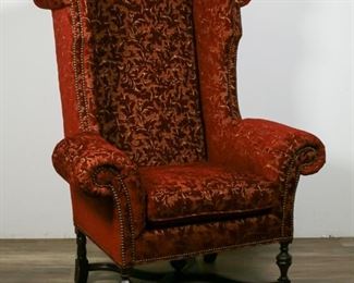 237	William and Mary Style Wing Chair by Lee Jofa	"William and Mary Style wing chair by Lee Jofa. American, 20th Century. Monumental wing chair with red and yellow upholstery with leaf motif, carved stretcher with pineapple finial. Lee Jofa furniture label underneath cushion. Some slight wear to carved feet, slight loss to back left foot.

57"" H x 42"" L x 26"" W"
