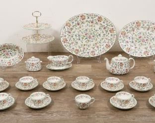 241	Minton Haddon Hall Porcelain Dinner Service for 12	Minton Haddon Hall porcelain dinner service for 12. 76 pieces: 2 tiered sandwich tray, 12 dinner plates, 12 salad plates, 12 Saucers, 12 dessert plates, 8 bowls, 2 oval platters,  12 tea cups, gravy dish with underplate, teapot, creamer and sugar, vegetable bowl. Mark circa mid 20th century. Discoloration to platter, wear to the underside from use.
