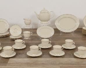 252	106 Pieces Lenox Jacquard Gold Porcelain	"106 pieces Lenox porcelain in the pattern Jacquard Gold. 13 dinner plates, 12 bowls, 15 footed cups, 15 saucers, teapot, creamer and sugar, 15 salad plates, 13 bread and butter plates, 12 dessert bowls, 2 vegetable bowls, 2 butter dishes, 2 relish dishes and 2 oval platters. 1 oval platter: 13 1/4"" L x 10 1/4"".
Chip to teapot spout. Wear to gilt on dinner plates. 
"