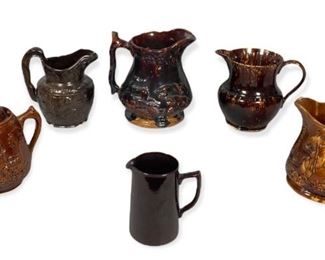 254	6 Pieces of Bennington Brown Pottery	"Collection of 6 brown pottery jugs including Bennington jugs.
4 pitchers, 3 decorated with hunt scenes.
A tall handled pot with lid.
A teapot with hunt scene, no lid.
Tallest: 10 1/2"" H x 6"" Diameter.
Chips to the underside of one pitcher. Chips to paint on one pitcher."