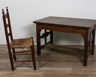        281	American Arts and Crafts Desk and Ladderback Chair	"American Arts and Crafts desk and ladderback chair. American, Early 20th Century. Mission oak, block legs and stretcher, one drawer with dovetailing and metal pulls. Heavy wear and scuffs to top of desk, small losses to block legs and stretcher. Mission ladderback chair with wicker rush seat, Early 20th Century, may be a Hackensack, NJ chair. Some wear and looseness to rush seat, minimal wear to splats and frame. 

Desk: 27"" H x 42' L x 26"" D
Chair: 38"" H x 18"" L x 15"" W"