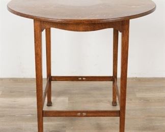        284	English Arts and Crafts Side Table	"English Arts and Craft side table. English, Early 20th Century. Quartersawn oak, gently tapered block legs, triangular hole carvings on stretcher. Furniture label on stretcher is very worn and is illegible. Some very slight wear to feet, slight scuffing and wear to top. 

28"" H x 30"" diameter

"