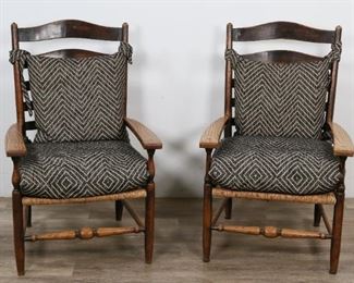       286	Pair of Shaker Style Ladderback Lounge Chairs	"Pair of Shaker style ladderback lounge chairs. 20th Century. Carved oak, ladderback splat form, wicker rush seats, geometric back and seat cushions. Slight wear to splats and legs. 

39"" H x 24"" L x 24"" W"