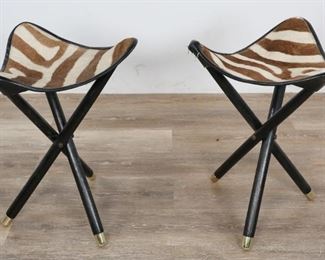        298	2 Mid Century Modern Zebra Hide Tripod Stools	"2 Mid Century Modern zebra hide tripod stools. American, Mid 20th Century. Triangular leather seats with zebra hide, ebonized dowel tripod supports with brass end caps. Wear and scratching to both supports, hide and leather seats are worn, cracking and tearing to  seat ""pockets"".

19"" H x 15"" L x 15"" W"