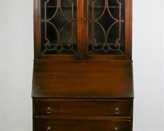        361	Rockford Furniture Mahogany Secretary	"Georgian style mahogany secretary. American, Early 20th Century. Slant front secretary desk, 3 lower dovetailed drawers, interior fitted with 2 drawers and cubby holes, 2 mullioned glass doors with key, 2 shelves. Manufactured in Rockford, Illinois by Rockford Chair and Furniture, label inside top drawer. Scuffs to feet, scratches on desktop, scuffs to shelves. Lock appears to be inoperable.

73"" H x 31"" L x 16"" D"