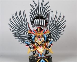        385	Indonesian Polychrome Garuda Statue	"Indonesian Garuda statue. Hand carved with polychrome and gilt  paint. Splitting to wood base, repairs to claws. Chip to paint on head. Lines to 2 feathers on wings. 
17 1/2"" H x 6"" base diameter."