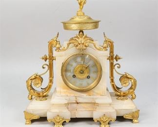        427	Gilbert & Son Belfast Alabaster & Gilt Metal Clock	"Gilbert & Son Belfast alabaster and gilt metal mantle clock. French style. Figural top with putto, mounted gilt flourishes. With key and pendulum. Loss to stone along the base. 
12"" L x 4 1/4"" W x 14 1/2"" H from base to top of putto."