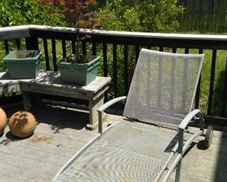 A third chase next to a potted Japanese red maple