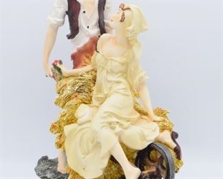Man Pushing Woman in Wheelbarrow Sculpture
