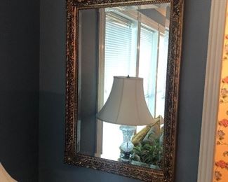 Gold frame mirror and white clear glass lamp
