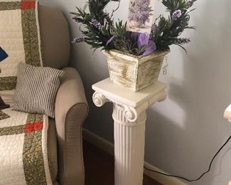 White column plant stand, decorative arrangement, quilt