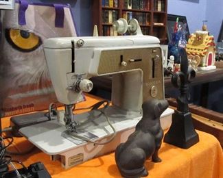 sewing machine with many extras in bad behind it