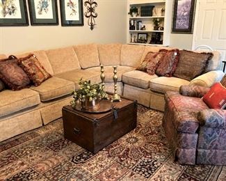 Comfortable and inviting gold-toned sectional; decorative pillows; occasional chair