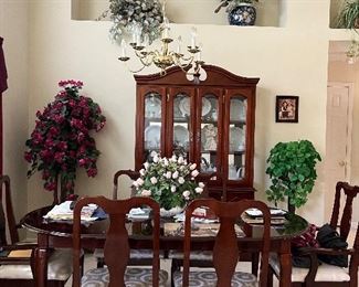 Beautiful dining table and curio as well as many floral arangements
