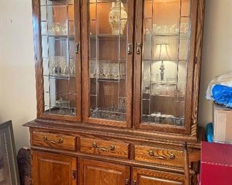 Oak china hutch with drawers, cabinets, and glass front.