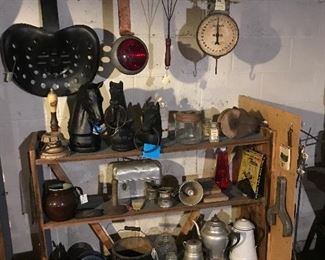 we have 4 cast iron hitching post horse heads, hay rake seat, 1 of the 2 old Jefferson City snow plow colored lights, wooden bucket, pulley. Hanson hanging scale. Note: top shelf/left corner shows a Schlitz berr tapper.