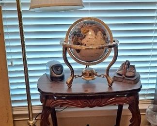 Brass lamp, antique table, copper baby shoes, gemstone globe
