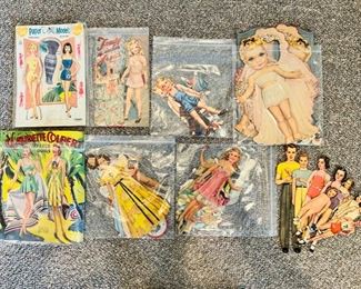 There is a large selection of vintage paper dolls, almost all with several outfits