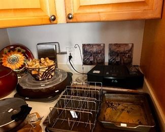 Bose radio, taco rack, waffle maker,basket of corks,cheese slicer, deviled egg box, sheet pans, cake pan sunflower decorative plate