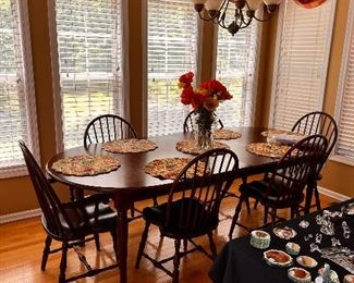Queen Anne dining table with two extra leaves, six bowback windsor chairs, floral arrangement, placemats
