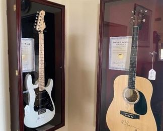Electric Guitar in glass and wood display case signed by Prince.                                                                                          
Acoustic Guitar in glass and wood display case signed by Ed Sheerin.                                                                                  
Both have certificates of authenticity. 