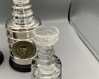 Lot 8811 $110.00 NHL Memorabilia Package, Includes: 2 Stanley Cup Replica Trophies from 2016 and 2017. Stanley Cup Trophy with melted ice, and Red Wing Stanley Cup 2002