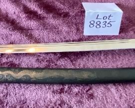 Lot 8835. $60.00. Katana Sword and Sheath. Sheath is made of plastic with Japanese Design.  The Blade is Sharp and Great Condition. Gold Fabric over Pebbled Rubber Grip.  35" L x 1" W Blade