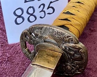 Lot 8835. $60.00. Katana Sword and Sheath. Sheath is made of plastic with Japanese Design.  The Blade is Sharp and Great Condition. Gold Fabric over Pebbled Rubber Grip.  35" L x 1" W Blade
