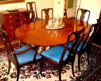 Vintage cherry dining room table with two extension leaves and eight chairs.