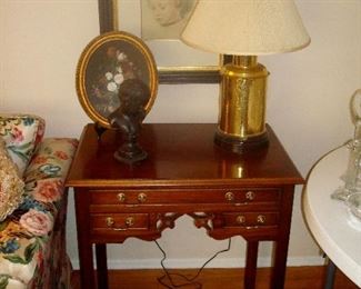 small oval oil painting, bronze figurine, brass base lamp,  print of child, all on Southampton cherry three drawer stand.