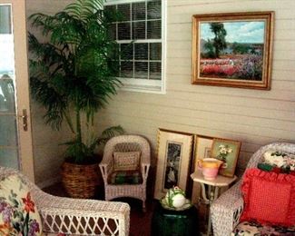 Oil painting on wall, child's wicker rocker, faux potted plant, lamp stand & vintage hand colored, water color prints..