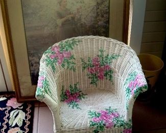 Child's wicker chair and framed print behind.