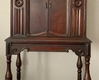 Knoxville Furniture CO Antique Radio Mahogany Cabinet with Double Doors, Raised on a Table Base with Turned Legs and with a Applied Scroll and Beaded Apron.  Cabinet (25 1/4”W x 17 1/4”D by 24 1/2”H).  Attached Base is 27 1/4”W x 18 1/4”D). Overall Height 51”