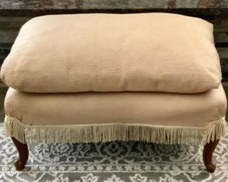 Vintage Ecru Upholstered Footstool with Separate Cushion Topper and Fringed Bottom Raised on Queen Anne Feet.  21” D x 28”W x 18”H with Cushion 