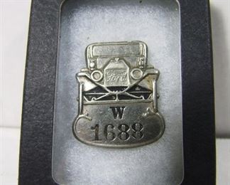 Lot 134   Rare 1918 Ford Model T employee plant badge. Has profile of Model T auto above the employee ID letter & number. Measures 1 ½” high. Cond. Minor wear from use.   $250 - $350