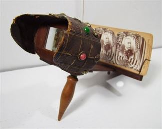 Lot 149   1890 Walnut Stereo Viewer & 9 Views of Span/Am War. Views incl. Dewey & Troops. Cond: Viewer has a jeweled leather eye shade that shows wear from use. 1 View has corner damage & 1 with water damage.   $75 - $125