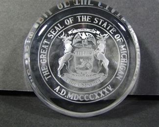 Lot 283   Etched Lead Crystal Michigan paperweight, circular form w/under etched Michigan State seal, 3 ½” dia. x 1 ½” h. Cond:  No damage found.  $30 - $60