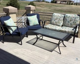 Metal patio furniture. Bench seat with cushions (corner of cushions damaged/frayed) H35" x W52" x D26". Two (2) chairs with cushions & pillows (pillows damaged/frayed, cushions by Hampton Bay) H35" x W28" x D30" Table with glass insert/top H18" x W42" x D24". No manufacturer tags unless noted.
