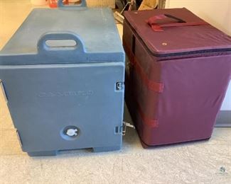 One Cambro blue hard plastic cooler with side door and inside tray slots, with handle, H 23"x W 16.5"x D 24". One Burgundy canvas cooler with zip-off top to expose styrofoam, no manufacturer's label found, H 20"x W 21"x D 13.5". Both are used condition.