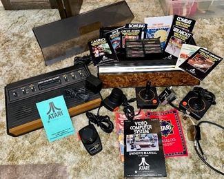 Atari CX 2600 original gaming console complete with manuals, four remote controls and 11 games with booklets, all in Tele-games Atari authorized custom game storage box with lid. 
