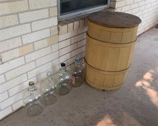 Many glass  jugs and cool wood barrel