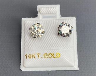 One pair stamped 10kt white gold ladies cast stud earrings with friction posts with a rhodium plated finish. Two basket set round cut moissanite, measuring 6.26x3.26mm, 1.65ct, .76gtw. Appraisal certificate included.