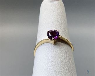 One stamped 10kt yellow gold combination cast and assembled ring with a bypass shank with a high polish finish. One prong set heart cut natural amethyst, 4.40x2.98mm, size 6, 0.88gtw, with appraisal certificate included.