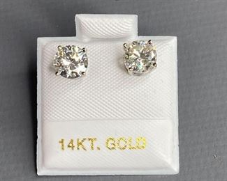 One pair stamped 14kt white gold cast stud earrings with rhodium plated finish. Two basket set round cut moissanites, measuring 5.90x3.18mm, 1.42ct, 1.00gtw. Appraisal report included.