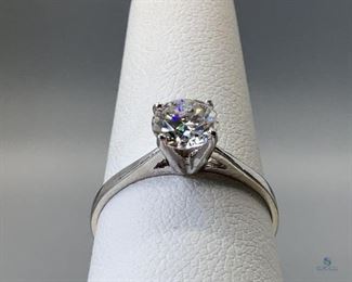 One stamped 10kt white gold cast solitaire ring with a rhodium plated finish. One claw set round cut moissanite 6.05x3.70mm, approximate 0.75ct, 1.34gtw, size 7, certificate of appraisal included.