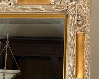 GILT WALL MIRROR | Very large gilt carved wall mirror with floral scrollwork carved accents and beveled glass; 52 x 42 in.