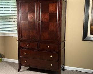 STANLEY FURNITURE ARMOIRE | Dark wood dresser cabinet with two checkered doors with contrasting woods opening to reveal a TV / entertainment console or optional use as a vanity with two interior drawers, all over a lower section with two half drawers over two full-width drawers; 49 x 72 x 27 in.