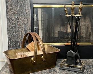 FIREPLACE EQUIPMENT | Including a set of five tools with brass handles on a fender-form stand and hammered brass basket / log holder
