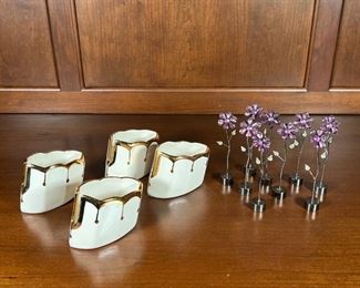 (13pc) MISC TABLE ITEMS | 9 name card holders by Torre & Tagus with costume gem flowers (h. 5 in.) and 4 ceramic gilt edge serving utensil rests signed "Zara" on bottom