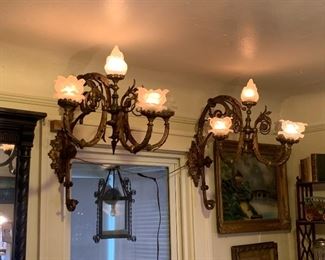 Turn of the century elegant victorian wall sconces with flame and flower shades out of a prominent downtown building